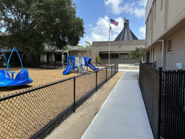 Black vinyl-coated chain link fence installed around a church and school playground in Orlando, FL by Alpha Omega Fence