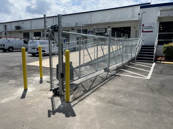 Commercial chain link fence with an automatic slide gate installed at an industrial property in Orlando, FL.